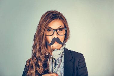 Resme yakından bak. Güzel, genç bir kadın ciddi bir erkeği taklit ediyor. Elinde kağıt bıyıklı çekici bir kız yeşil arka planda. Olumlu insan duyguları, yüz ifadeleri