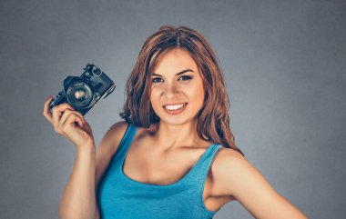 Fotoğrafçı. Yakın plan portresi, elinde DSR kamerayla gülümseyen genç bayan. Düğün gezisi fotoğrafçılığı hobisi paparazziler. Karışık ırk modeli gri, gri arkaplan