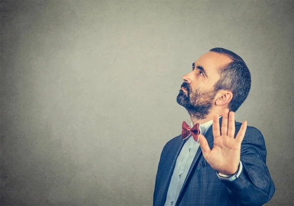 Hombre en traje elegante con pajarita roja mostrando señal de stop sobre fondo gris. Emoción humana negativa expresión facial sentimiento lenguaje corporal — Foto de Stock