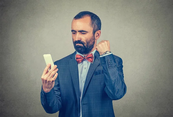 Homem olhando para o telefone e apertando o punho para o celular — Fotografia de Stock