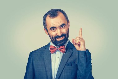 Dikkat! Zarif sakallı iş adamı yukarı bakıyor ve kameraya bakıyor. Yüz ifadesi, duygu simgesi, vücut dili, sözsüz iletişim. Üniforma arkaplanı.