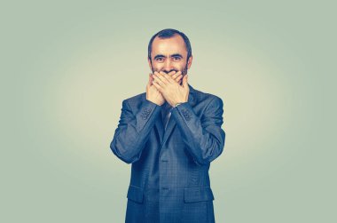 Gülümseyen adam elleri ve avuçlarıyla ağzını kapatıyor.