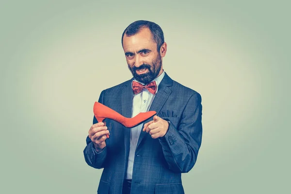 Man holding a red high-heeled shoe, pointing at you with finger — Stock Photo, Image