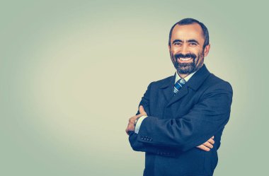 Adam kameraya bakıp neşeyle gülümsüyor.