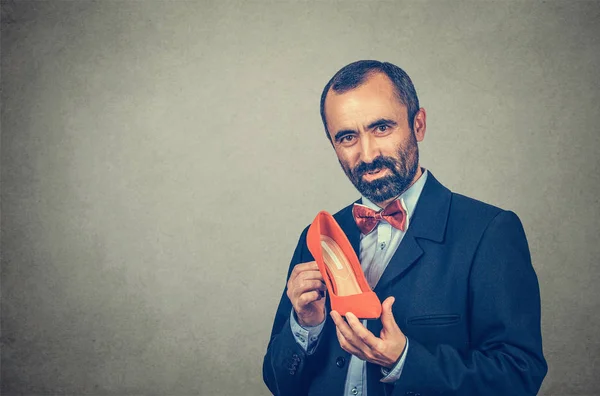 man holding one high heel shoe