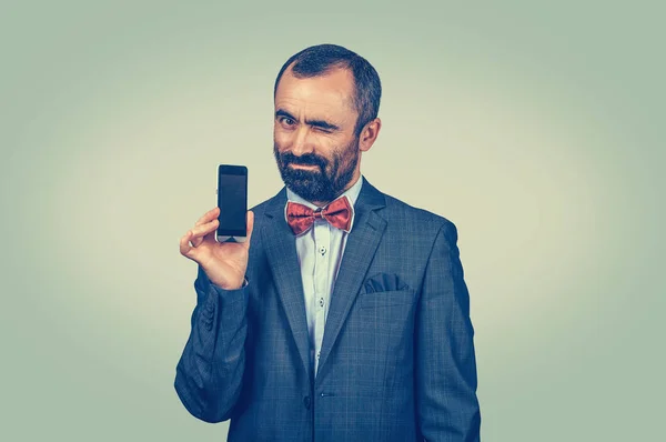 Hombre de negocios confiado mostrando la pantalla del teléfono inteligente en blanco — Foto de Stock