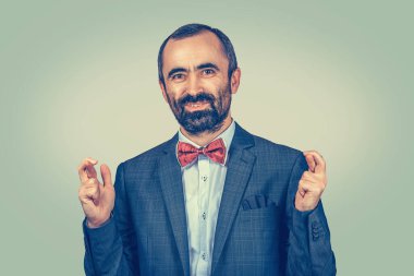 Yetişkin, orta yaşlı, komik bir adamın yakın plan portresi,... iş adamı şans diliyor, en iyisini umuyor,... yeşil arka planda izole edilmiş bir mucize. İnsani duygular, yüz ifadesi...