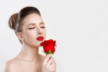 The woman with a red rose closeup eyes closed. Isolated on white