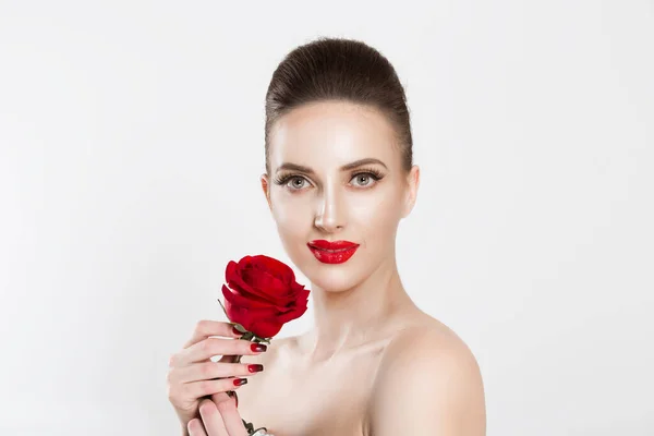 Hermosa como una flor. Mujer sosteniendo una rosa roja, mirándote la cámara aislada de fondo blanco. Morena, cabello oscuro, pestañas postizas maquillaje natural rojo negro gradiente labios uñas combinación conjunto —  Fotos de Stock