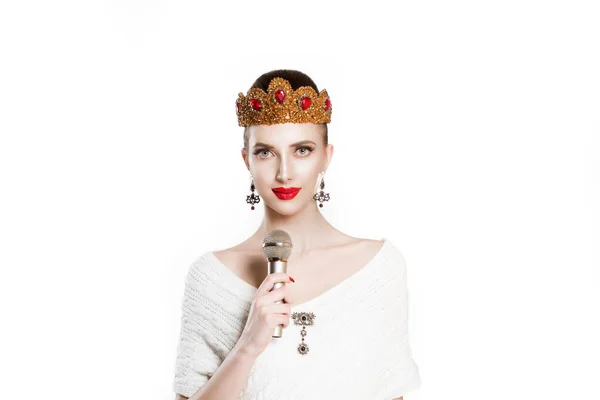 Σύγχρονη δημοσιογράφος. Δεσποινίς που τραγουδάτε καραόκε έχοντας προπαγάνδα λόγου σε απομονωμένο λευκό φόντο μικροφώνου. Κορίτσι με χρυσό ρουμπινί στέμμα κοσμήματα κόκκινα χείλη τέλειο μακιγιάζ, μικρόφωνο — Φωτογραφία Αρχείου