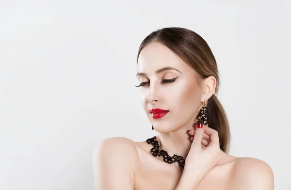 Young woman presents her earrings, holds your left hand on the right earring, her eyes closed isolated white background. Enjoying moment feelings sensuality concept — 스톡 사진