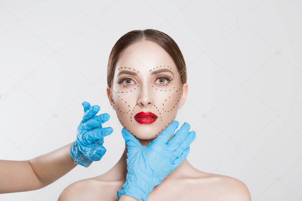 Facial cosmetic plastic surgery. Doctor surgeon hand in glove draw wrinkle lines on Woman face isolated white background. Sculpting reshaping Wrinkles fat removal cosmetic filling operation concept