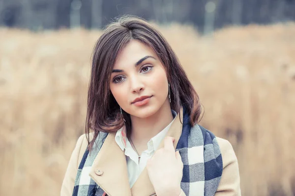 Sensual portrait of a woman, beautiful face female enjoying nature, thinking dreamy girl in beige coat and blue white scarf outdoor isolated on autumnal nature park background — Stock Photo, Image