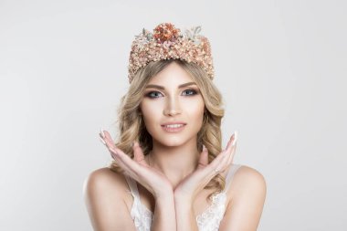 Beauty bride with pastel colors makeup silver crown looking at you camera smiling. Beautiful face of young adult woman with clean fresh skin hands around face- isolated on white background studio wall