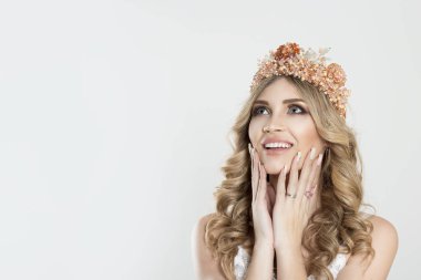 Happy and beautiful. Beauty crowned queen girl woman actress miss bride smiling laughing looking up to the copy space hands on face isolated white wall. Full makeup, diamond silver pink crystals crown