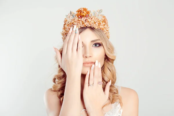 Beauty crowned queen girl woman miss bride hand around, on, covering face showing manicure gel art nails looking at you camera on white. Full makeup diamond golden pink crystals crown pastel colors — 스톡 사진