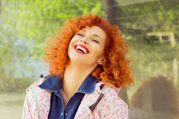 Belle femme aux cheveux bouclés rouges riant, isolée à l'extérieur. Le bonheur. Émotion humaine positive expression faciale . — Photo
