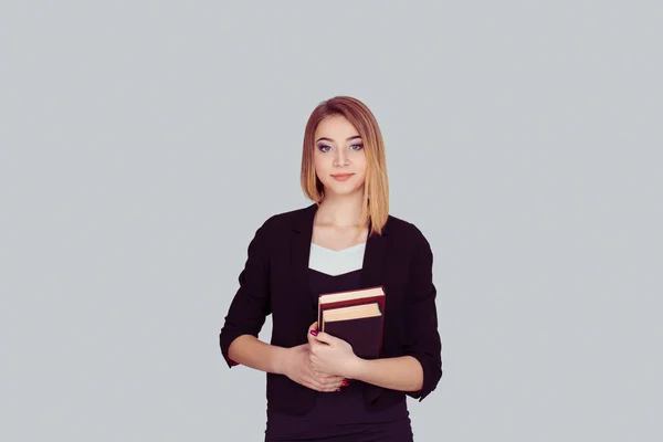 Studente sorridente che trasporta uno zaino e tenendo pila di libri i — Foto Stock