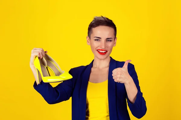 Szczęśliwa kobieta zęby uśmiech pokazując żółty wysokie obcasy buty — Zdjęcie stockowe