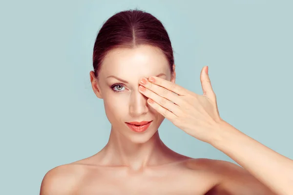 Juego de combinación de uñas y labios de color rosa beige. Hermosa mujer joven que cubre su ojo con su mano desnuda maquillaje natural uñas manicura hecho lápiz labial de coral aislado luz verde fondo estudio pared — Foto de Stock