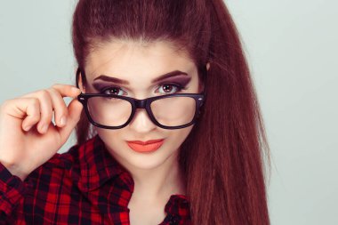 Kafası karışmış şüpheci bir kadın sana bakarken onaylamadığı gözlüğünü indirirken şüpheli bir şekilde izole edilmiş açık yeşil arka plan.