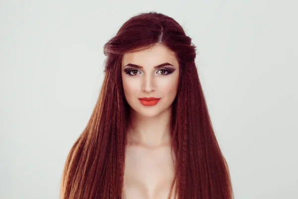 Piękna kobieta z długimi włosami patrząc na ciebie aparat lekko uśmiechnięty odizolowane białe szare tło. Pełny makijaż brunetka brązowe włosy, czerwone usta — Zdjęcie stockowe