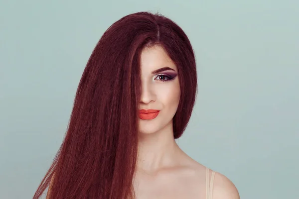 Piękny portret kobiety z połową twarzy pokrytej długimi brązowymi włosami uśmiechnięte rude włosy na jasnozielonym tle — Zdjęcie stockowe