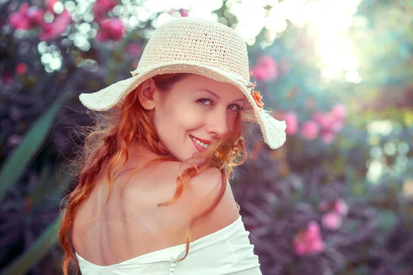 Summer girl portrait looking back. Mixed age woman turned back smiling happy on sunny summer or spring day outside in park by lake. Pretty mixed race Caucasian / Chinese Asian young woman outdoors.