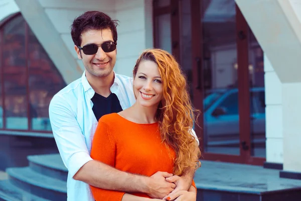 Felizes juntos. Romântico jovem casal hispânico sorrindo de pé perto de apartamento complexo cidade fundo — Fotografia de Stock