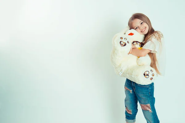 Kleines Mädchen umarmt Teddybär schaut in die Kamera — Stockfoto