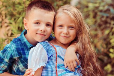 Kardeşi olan kız kardeş sevgi gösterir, kucaklar ve güler doğa yeşil çalı arka planı