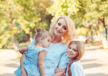 Neşeli anne ve iki kız şehirde eğleniyor.