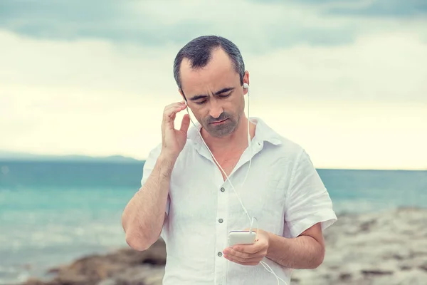 Uomo che ascolta musica. Video chat in vacanza. Uomo di regolazione vo — Foto Stock