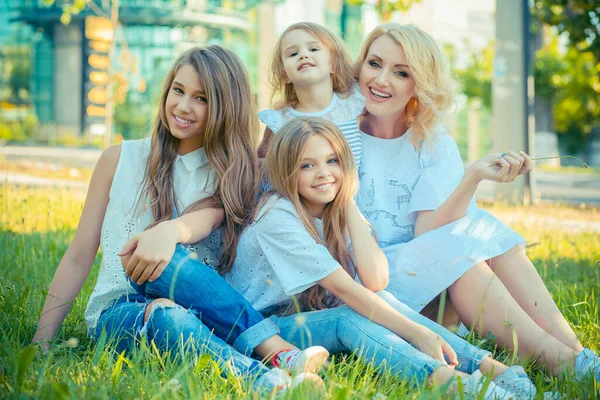 Feliz foto de família. Closeup retrato foto toothy sorrindo três meninas bonitos, sua mãe quatro membros da família apenas mulheres na grama isolada fora ao ar livre parque da cidade de fundo. conceito de felicidade — Fotografia de Stock