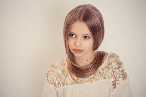 Menina de criança elegante bonita com cabelos longos em torno de seu pescoço como um colar isolado no fundo marrom claro branco olhando para o lado posando — Fotografia de Stock