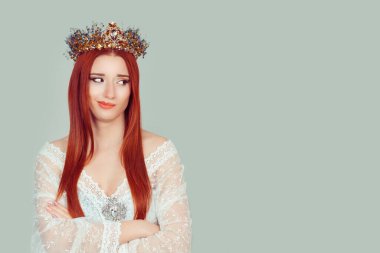 Kıskanç güzellik kraliçesi. Kıskanç kadın, açık yeşil arka plan duvarında izole edilmiş kafasında kristal taç olan iğrenç güzel kadına bakıyor. Negatif insan duyguları