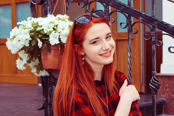 Mujer feliz sentada en las escaleras, mirando a la cámara con sonrisa dentada, al aire libre — Foto de Stock