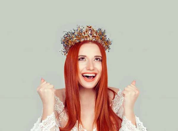 Happy beauty queen woman exults pumping fists ecstatic celebrates success pretty woman with crystal crown on head isolated on light green gray background
