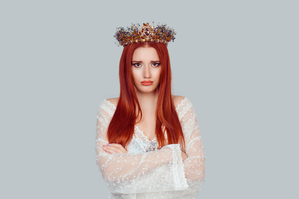 Portrait upset beauty queen, woman looking suspicious, disapproval on face arms crossed folded unhappy pretty woman with crystal crown on head isolated on light gray
