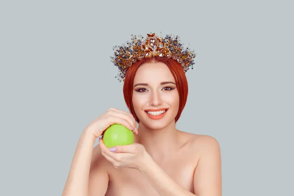 One apple a day keeps doctor away. Beauty queen smiling holding green apple toothy smile pretty woman with crystal crown on head isolated on light green gray — Stock Photo, Image