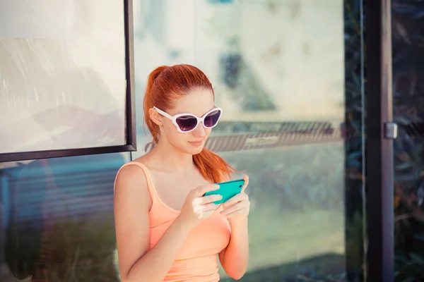 Κορίτσι γραπτών μηνυμάτων σε smartphone. Νεαρή γυναίκα που χρησιμοποιεί το κινητό της τηλέφωνο σε σταθμό λεωφορείων έλεγχο μήνυμα sms e-mail ή το πρόγραμμα τραμ λεωφορείο. — Φωτογραφία Αρχείου