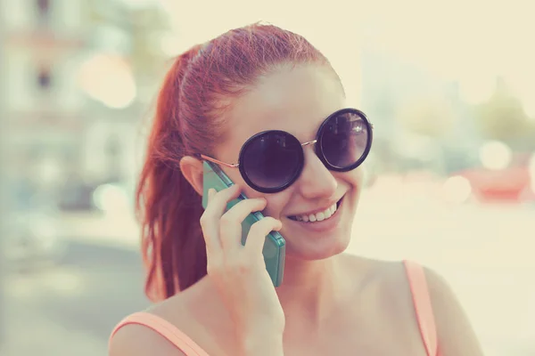 Mulher eufórica conversando com seu telefone inteligente em uma estação de ônibus — Fotografia de Stock