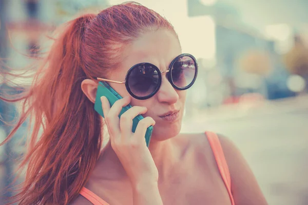 Сердита жінка розмовляє по телефону. Крупним планом молода нещаслива розчарована розчарована красива жінка-леді, що говорить на мобільному телефоні на міському пейзажі на відкритому фоні . — стокове фото