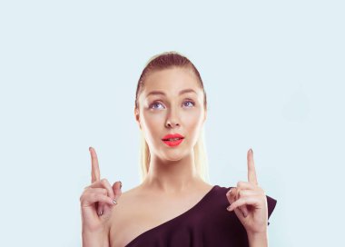 Yukarı bak. Başının üstünde işaret parmaklarıyla fotokopi alanını gösteren güzel bir kadın açık mavi duvar arkaplanı at kuyruğu saçı pembe dudaklar açık omuzlar açık siyah elbise açık makyaj