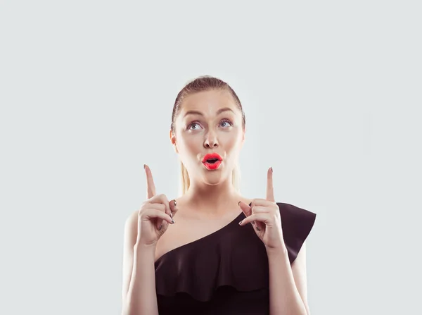 Wow. Closeup portrait young woman beautiful girl with excited holding her mouth opened, hands index fingers pointing up isolated white light blue background. Shocked surprised stunned. Human emotion — 스톡 사진