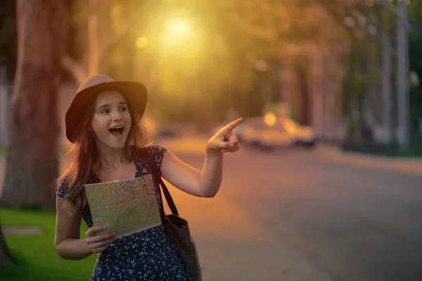 Tourist happy excited to find looking at showing a landmark. Beautiful asian woman looking or find attractions on a map when traveling in the city, girl, wow face expressions pointing away in evening