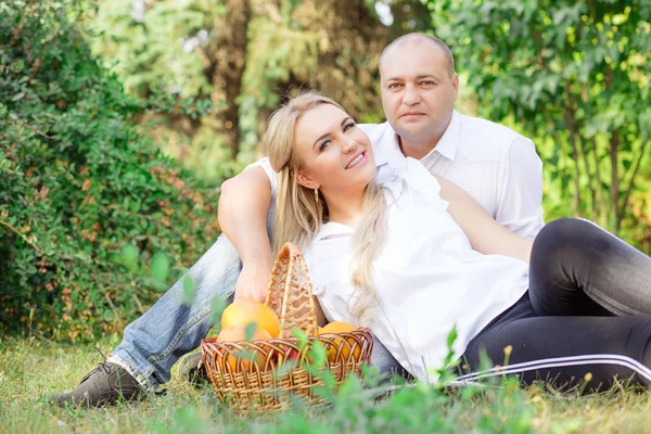Happy couple outside hugging and posing having picnic isolated outdoors green foliage background