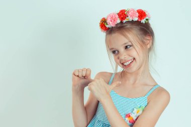 Kadın kendini gösterip gülümsüyor ve gururla evet diyor. Bu benim. Beyaz gri arka planda izole edilmiş çiçek tokalı beyaz çocuk modeli yakın plan portresi.