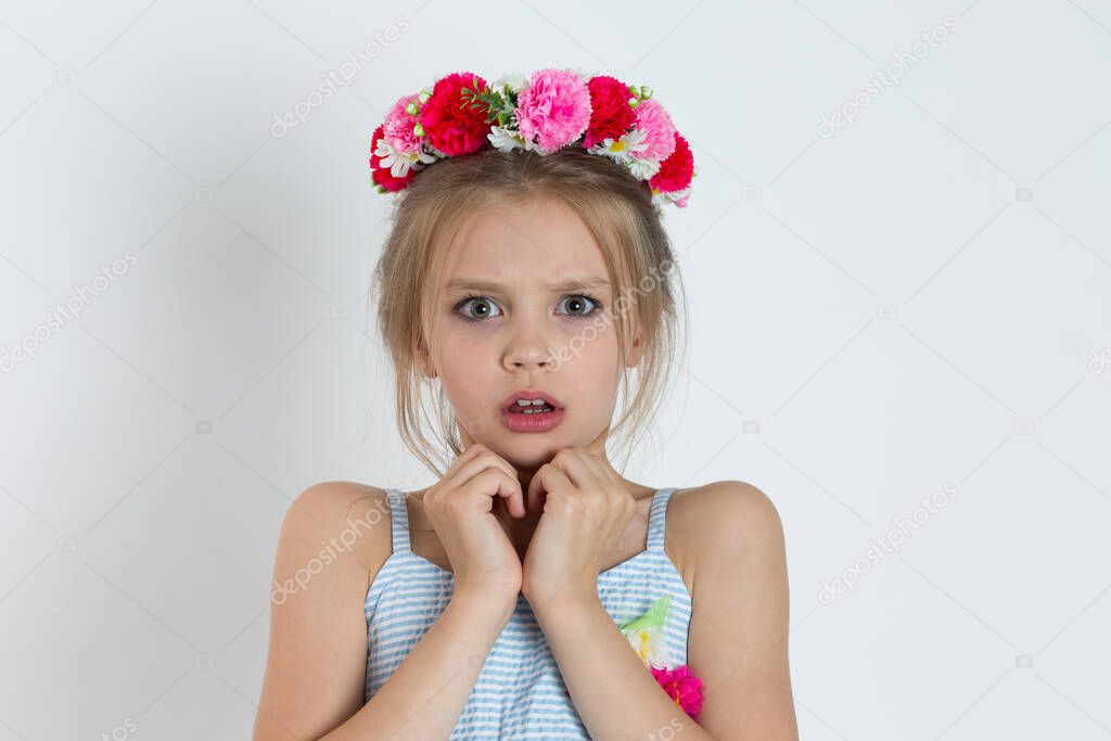 Portrait closeup frightened shocked scared girl looking at camera. Emotion face expression body language unexpected reaction. Caucasian kid model with floral headband isolated on white gray background
