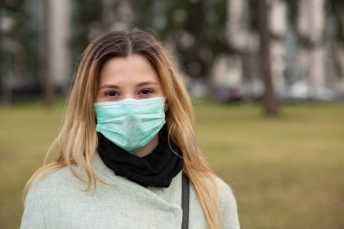 Koronavirüse karşı steril koruyucu bir maske takan neşeli bir kadın, Asya pandemik sars virüsü, sana bakıyor, kamera mutlu.. 